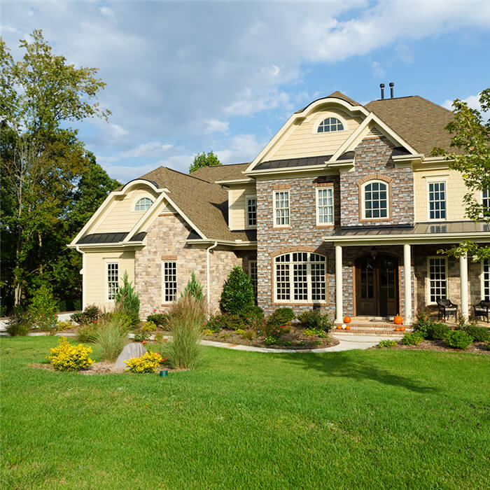 cottage style stone exterior house surrounded by a beautiful landscape.jpg